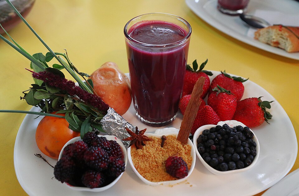 Vaso de colada morada con frutas y especias